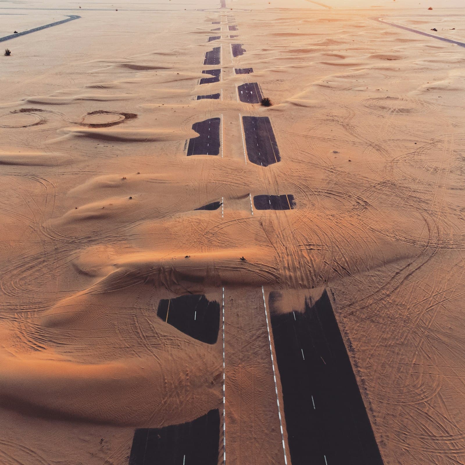 Aerial view of desert land running alongside a paved access road, Jebel Ali Hills, Dubai